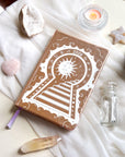 Stunning Decorative 2026 Moon Planners / notebooks with 2026 design on a white surface with candles and crystals. 2026 planner. Witchy Planner 2026