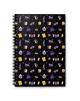 A spiral-bound journal with a black cover featuring a whimsical witch design with various symbols and shapes in purple, gold, and white colors.