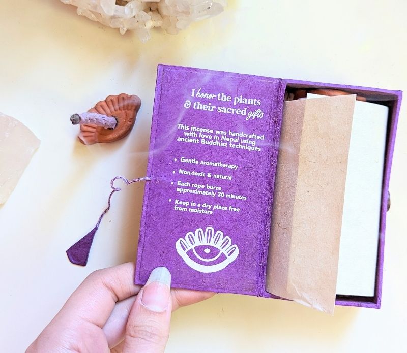 Stupa Smoke Rope Incense with product description inside box and woman's hand holding the box open