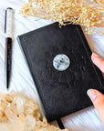 A5 celestial journal made from recycled paper, with 120 lined pages and embossed moon phases design on black vegan leather. Perfect for magical moments and daily to-dos.