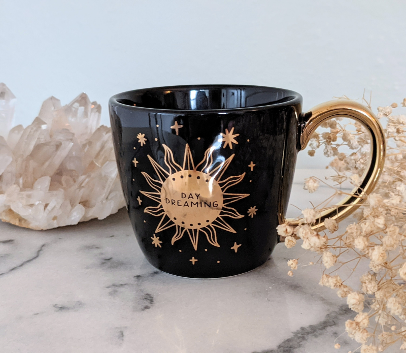 Black and celestial ceramic mug with moon and sun design available at Goddess Provisions