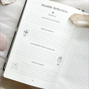 Interior pages of the 2026 planner showing monthly and weekly layouts, goal sections, and intention prompts.