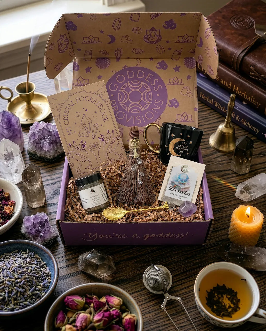 April subscription women box featuring crystal ritual set with tea, notebook, spoon, facial steam, broom, and amethyst crystal