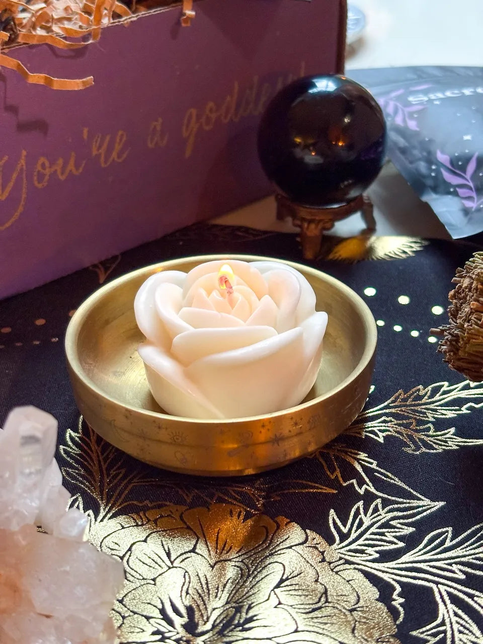 White candle with rose design symbolizing peace, purity, and honoring ancestors.