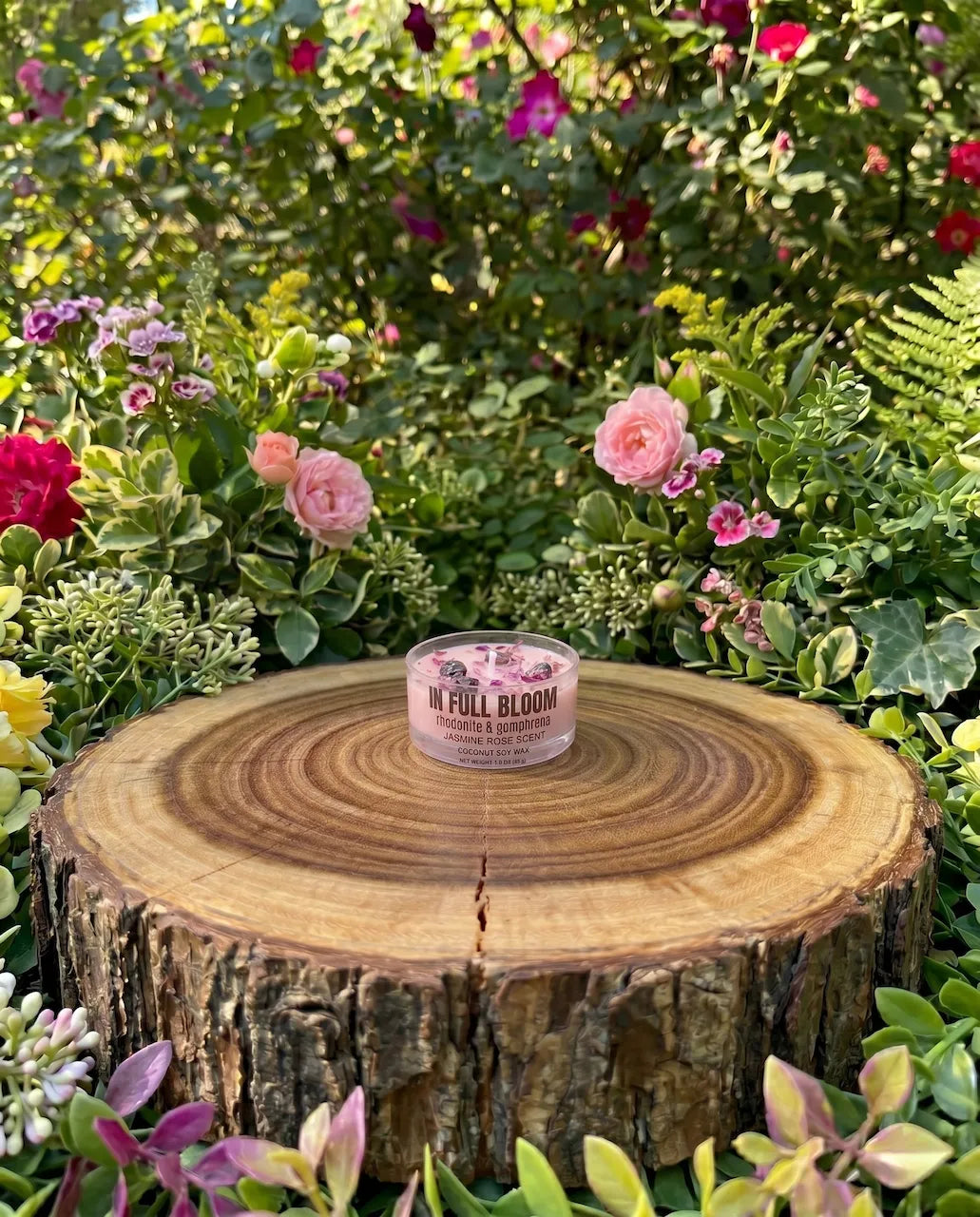 crystal ritual candle with rhodonite stones and dried gomphrena flowers for self love rituals