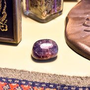 Tumbled Iolite stone with a glossy finish and rich blue color
