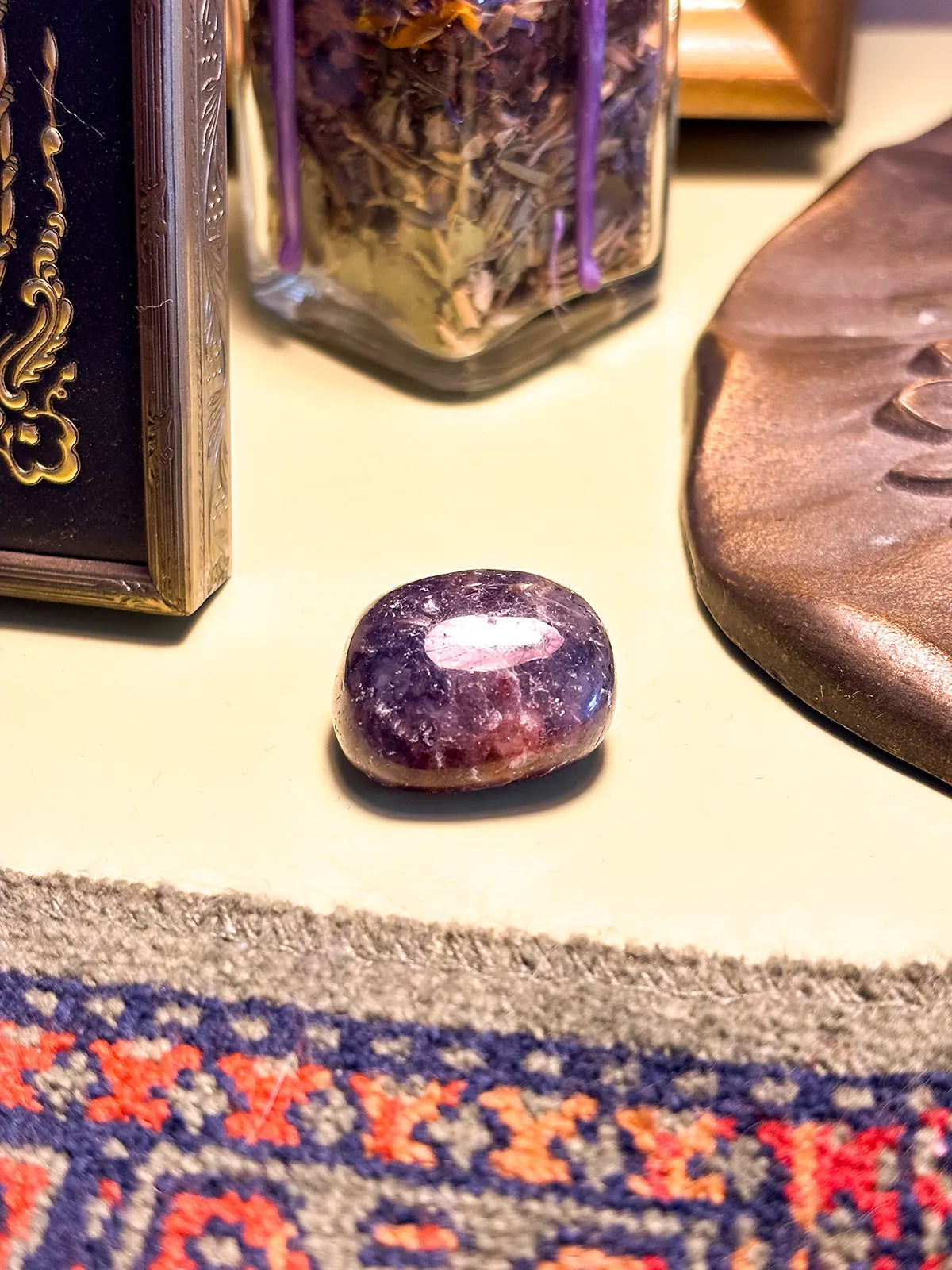 Tumbled Iolite stone with a glossy finish and rich blue color