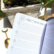 Dreamy moons manifest workbook featuring journal prompts and vision boards. Available at Goddess Provisions