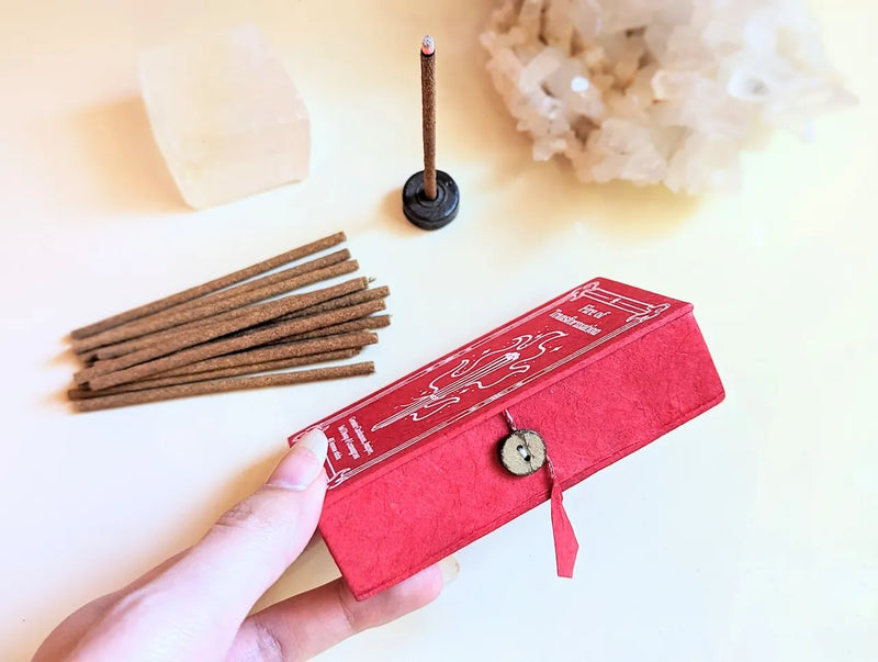 Burning incense sticks releasing soft smoke beside meditation decor and mystical altar accessories.