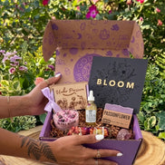 women’s spiritual subscription box for May with floral ritual tools, shimmer oil, candle, soap, and cherry quartz crystal