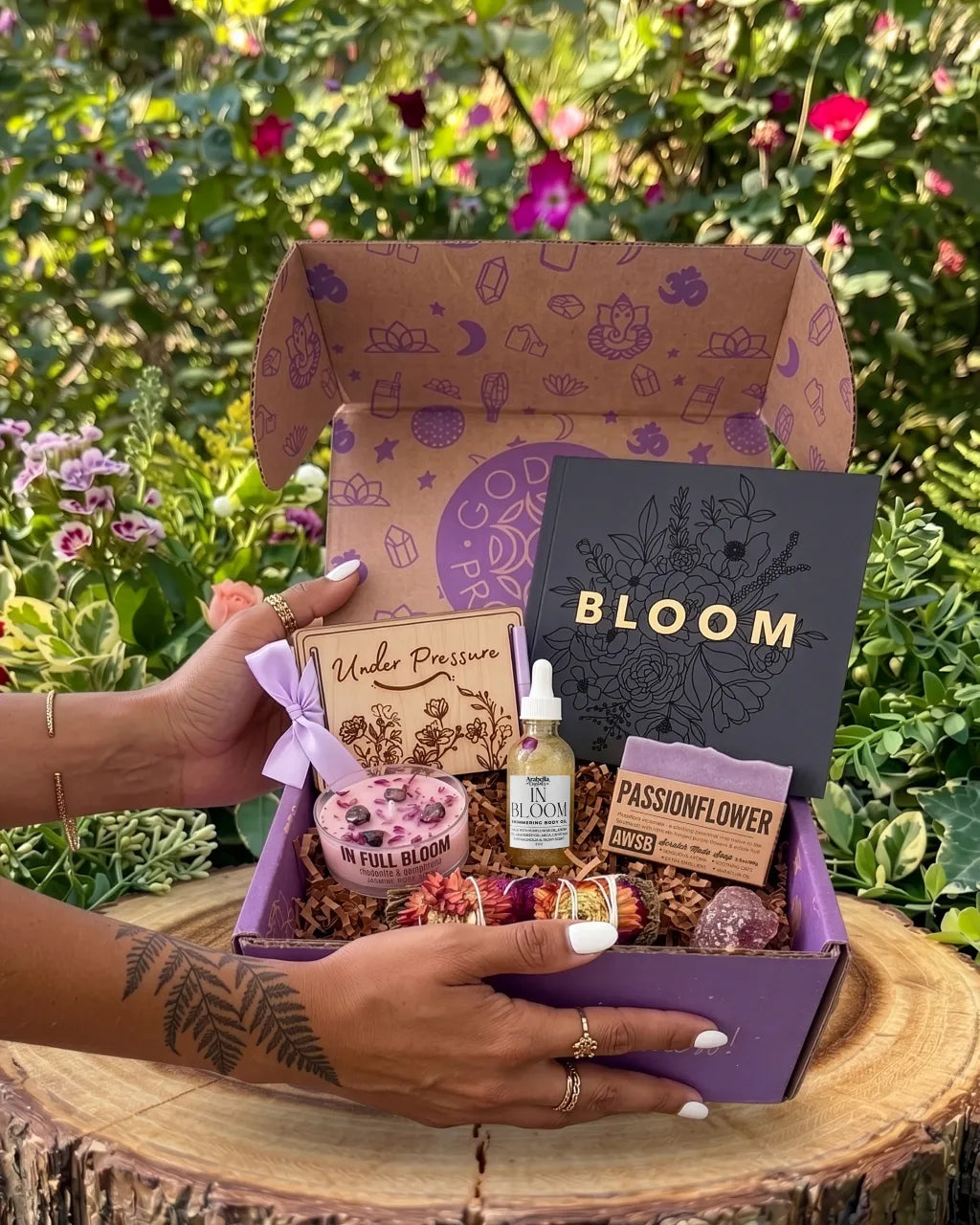 women’s spiritual subscription box for May with floral ritual tools, shimmer oil, candle, soap, and cherry quartz crystal