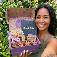In Bloom spiritual subscription box with self care rituals, lavender smudge wand, body oil, crystal candle, and healing crystal