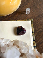 Heart-shaped garnet and astrophyllite stone for passion and spiritual insight.