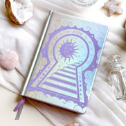 Stunning silver planner decorative 2026 Moon Planners / notebooks with 2026 design on a white surface with candles and crystals. Goddess Provisions Planner - Exclusive