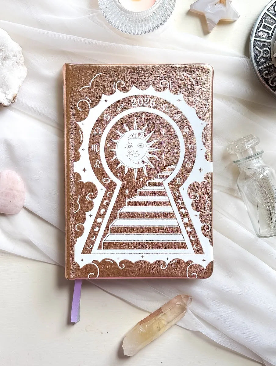 Stunning Gold/champaign planner decorative 2026 Moon Planners / notebooks with 2026 design on a white surface with candles and crystals. Goddess Provisions Planner - Exclusive