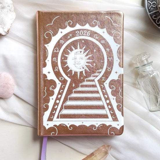 Stunning Gold/champaign planner decorative 2026 Moon Planners / notebooks with 2026 design on a white surface with candles and crystals. Goddess Provisions Planner - Exclusive
