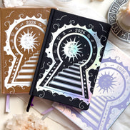 Stunning silver planner decorative 2026 Moon Planners / notebooks with 2026 design on a white surface with candles and crystals. Goddess Provisions Planner - Exclusive