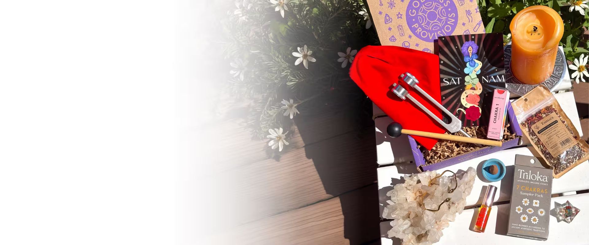 Collection of items including a candle, crystals, and tarot cards on a white background.