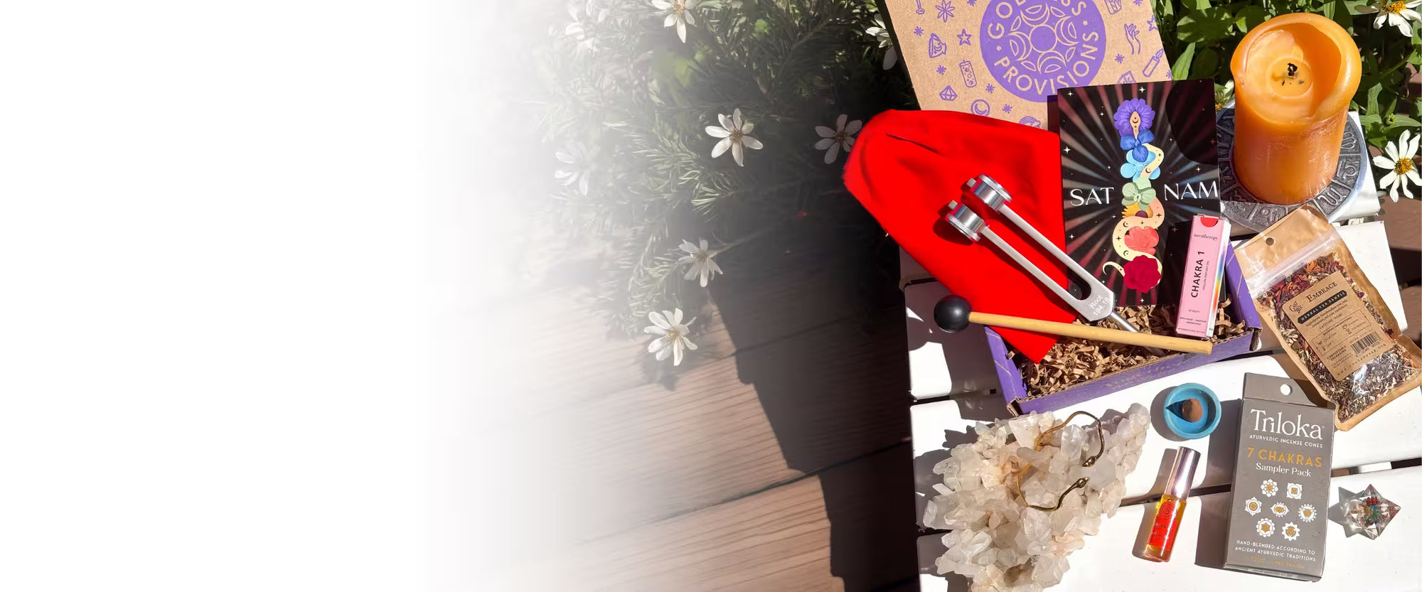 Collection of items including a candle, crystals, and tarot cards on a white background.