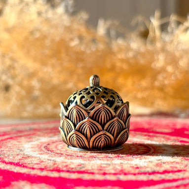 Ceramic hollow lotus incense burner with delicate floral cutouts for aromatherapy and meditation décor.