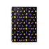 A spiral-bound journal with a black cover featuring a whimsical witch design with various symbols and shapes in purple, gold, and white colors.