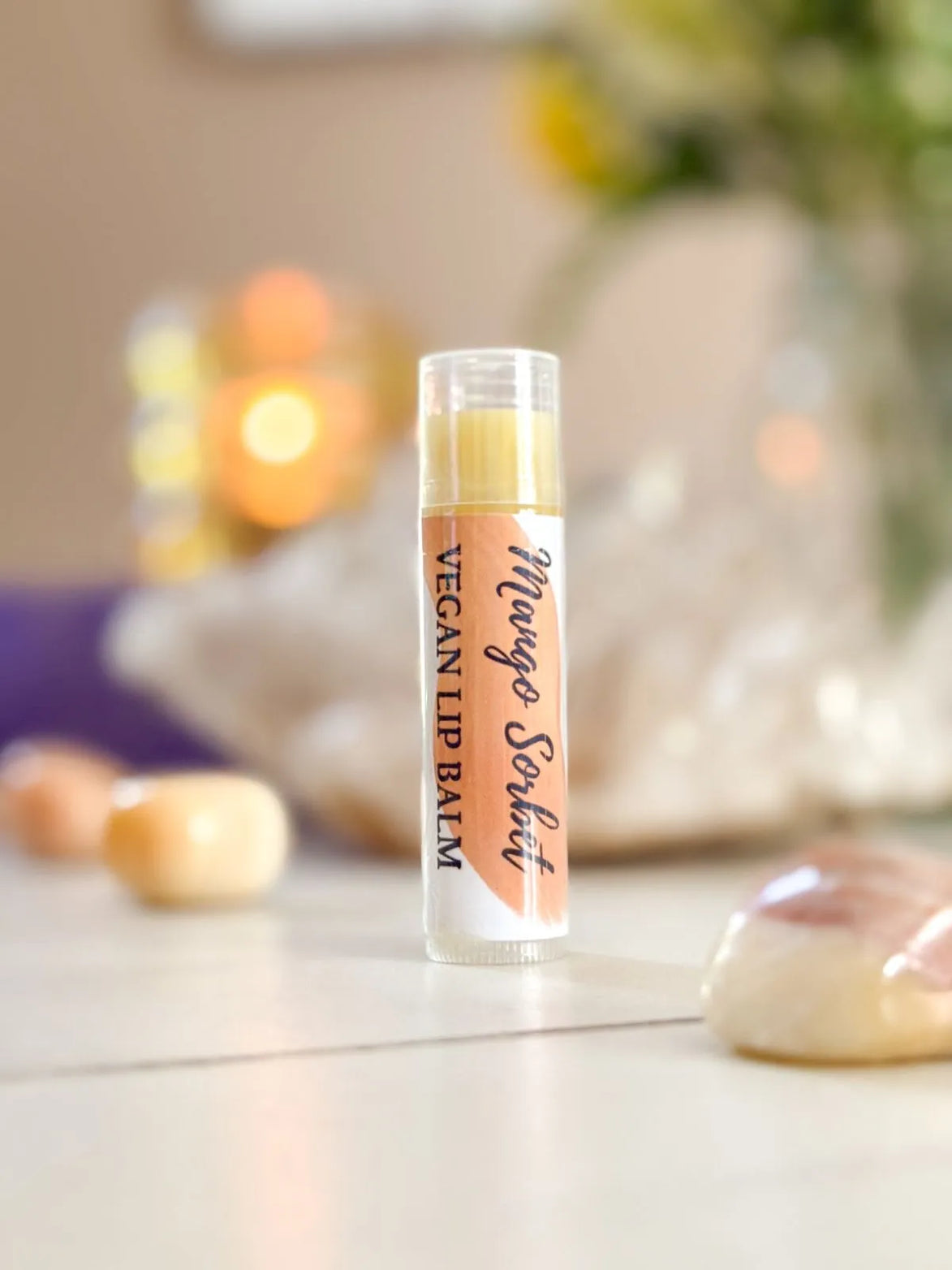 Organic vegan lip balm labeled Juicy Mango Sorbet with tropical mango flavor.