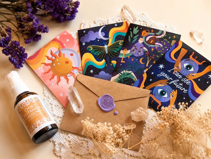 Close-up of recycled paper greeting cards featuring mystical illustrations and colorful magical designs.