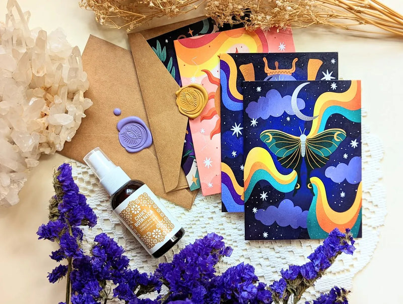 Magical Memos greeting cards with celestial artwork and matching envelopes displayed on a soft neutral background.