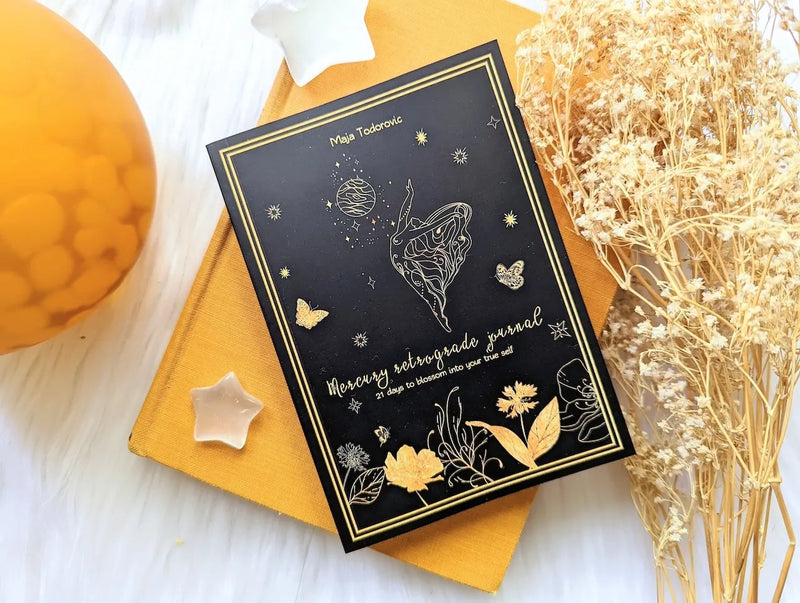 Open Mercury Retrograde journal displayed with crystals, candles, and astrology-inspired decor.