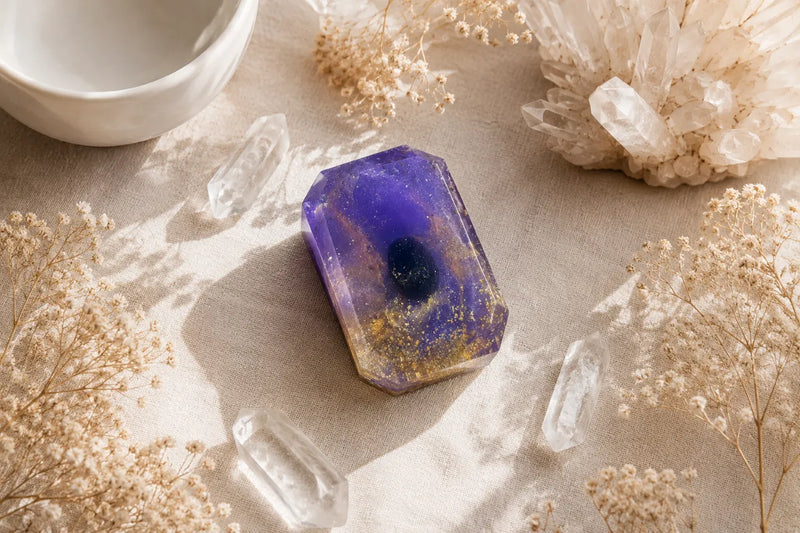 Black obsidian crystal soap bar with shimmering details and botanical ingredients displayed beside crystals.