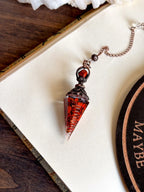 Handcrafted red jasper and copper pendulum for grounding and spiritual work.