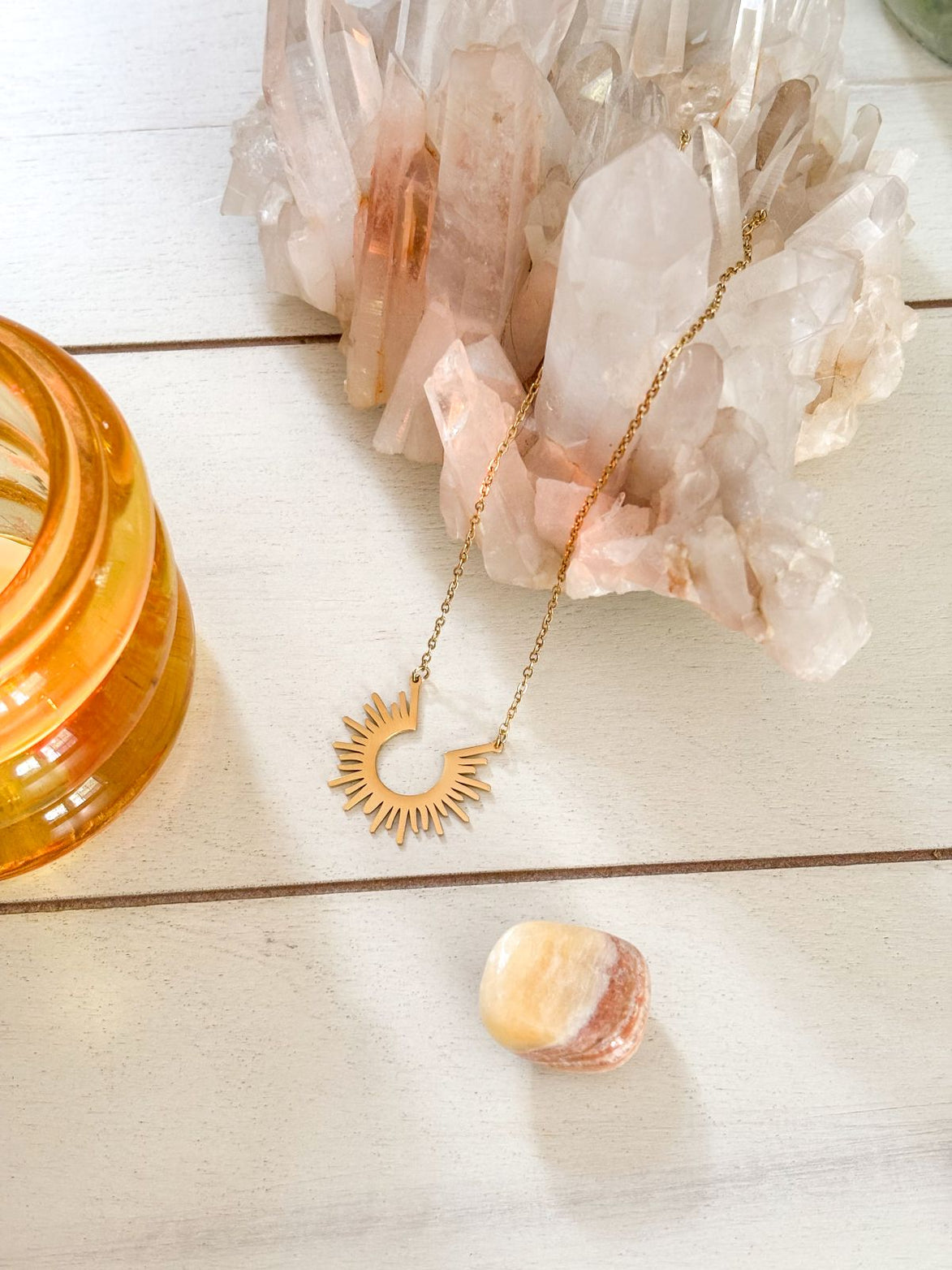 Gold-plated stainless steel sun pendant necklace with celestial design.