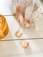 Gold-plated stainless steel sun pendant necklace with celestial design.