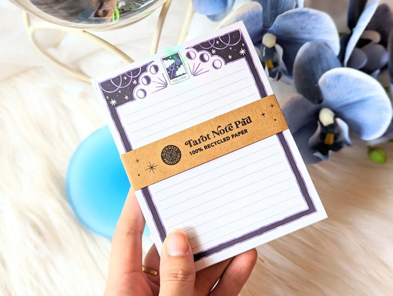 Mystical tarot-inspired notepad with vibrant illustrated pages styled on a desk workspace.