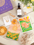Collection of items including a bottle labeled 'After Sun', cards, and crystals on a wooden surface.