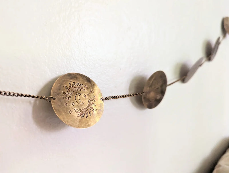 Long brass zodiac wall hanging styled in a cozy spiritual space with mystical home decor accents.
