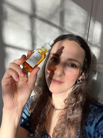 Amber-colored serum in a dropper bottle for Natural Hair Rejuvenation with Earth Harbor