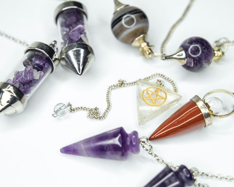 Assorted crystal and stone pendulums with silver chains for spiritual guidance