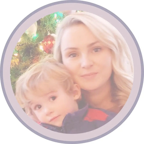 Blonde woman and young boy celebrating Christmas in front of a decorated tree
