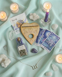 Goddess Provisions ritual box with oracle cards, a spirit board, crystals and candles on silk
