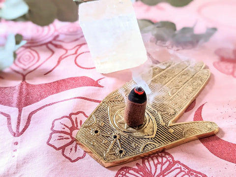 Burning incense cone in hand-shaped holder for Moontime Celebration Ritual