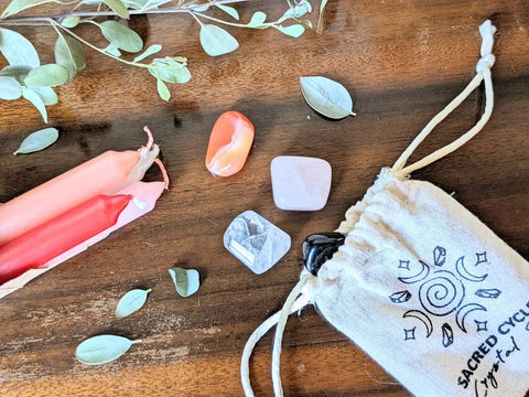Candles crystals and a drawstring pouch for a Moontime Celebration Ritual
