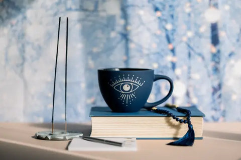 Dark blue mug with a white eye design featured in The Deep Magic of Mugwort article