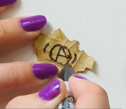 Dried leaf with drawn symbol for Car Protection Spell Pouch article