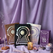 Set of tarot books and candles on a purple fabric background