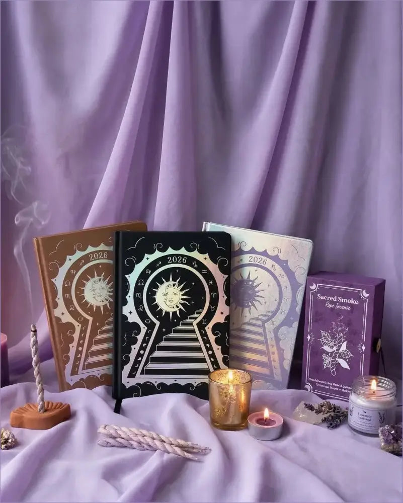 Set of tarot books and candles on a purple fabric background