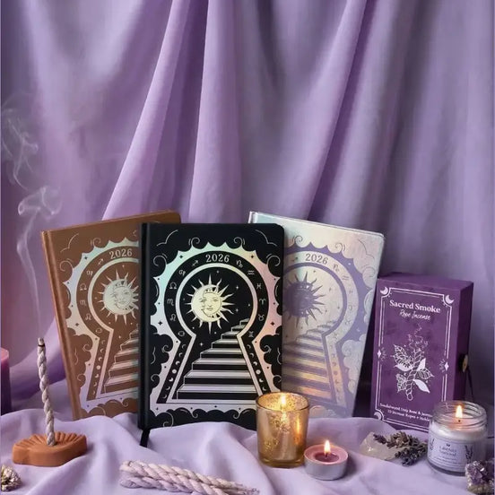 Set of tarot books and candles on a purple fabric background