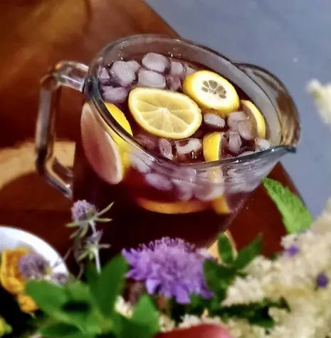 Glass pitcher of iced tea with lemon slices for summer nights