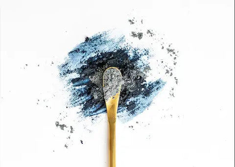 Golden spoon holding gray powdered eyeshadow in Herbal Allies for Energy article