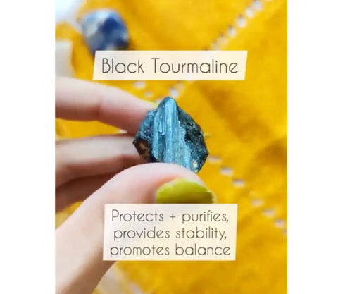 Hand holding black Tourmaline crystal with a striking blue sheen for Mercury Retrograde article